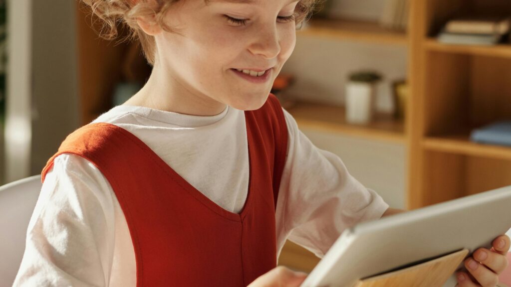 A child on tablet for teletherapy in school; SoundEd Therapy for schools